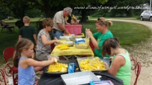 Tradition dictates that the adults cook and cut corn, and the kids bag it. 